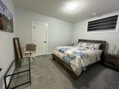 a bedroom with a bed and a glass table at Arriva Homestay in Calgary