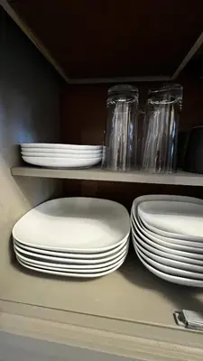 a group of plates and bowls on a shelf at ALL NEW 2BR Loft in Chilliwack