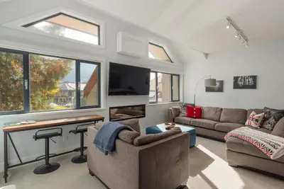 a living room with two couches and a tv at Tantalus Penthouse Mountain and Village Views in Whistler