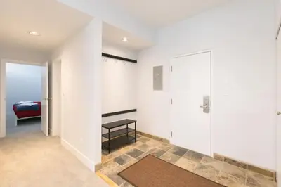 a room with white walls and a door with a table at Tantalus Penthouse Mountain and Village Views in Whistler