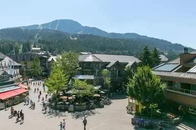 a group of people walking around a town with mountains at Tantalus Penthouse Mountain and Village Views in Whistler