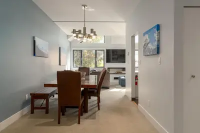 a dining room and living room with a table and chairs at Tantalus Penthouse Mountain and Village Views in Whistler