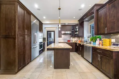 a large kitchen with wooden cabinets and a large island at Jovehouse in Vancouver