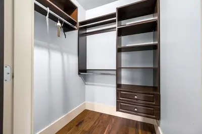 a walk in closet with black cabinets and wood floors at Jovehouse in Vancouver