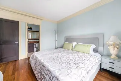a bedroom with a large white bed and a lamp at Jovehouse in Vancouver