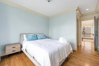 a bedroom with a bed with blue pillows on it at Jovehouse in Vancouver