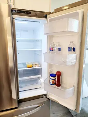 an open refrigerator with bottles of water and milk at Luxury Cozy Basement in Leduc
