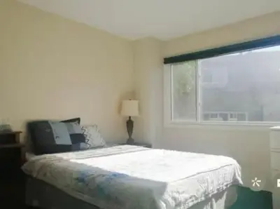 a white bedroom with a bed and a window at greenview mck sunny room in Calgary