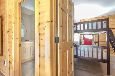 a bedroom with a bunk bed and a bunk room with a bathroom at Snow Pines by StayIn in Fernie