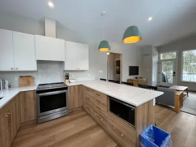 a large kitchen with white cabinets and a counter top at 4595 Alpine Way by StayIn in Fernie