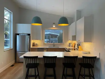 a kitchen with a large island with four bar stools at 4595 Alpine Way by StayIn in Fernie