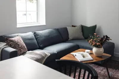 a blue couch in a living room with a table at The Brickworks at the 1896 Building in Kaslo
