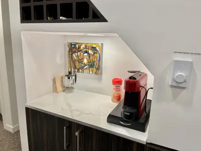 a counter with a coffee maker and a painting on the wall at The BIRDs NEST in the Benchlands in Whistler