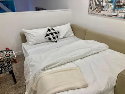 a bedroom with two beds with white sheets and a pillow at The BIRDs NEST in the Benchlands in Whistler