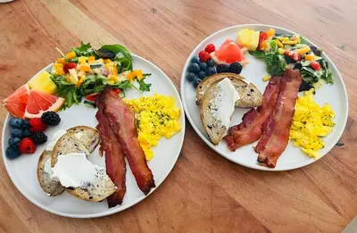 two plates of breakfast food on a wooden table at Hikari-Okanagan Sunshine B&B in Kelowna