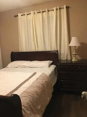 a bedroom with a bed and a dresser and a window at Renovated 4 bedrooms 20 sleeps Shopping Center in Edmonton