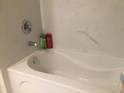 a bathroom with a white bath tub and a toilet at Renovated 4 bedrooms 20 sleeps Shopping Center in Edmonton
