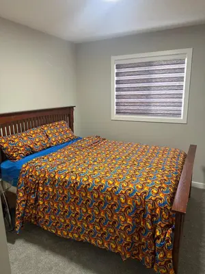 a bedroom with a bed with a comforter and a window at 3 Bedroom House in NW Calgary in Calgary