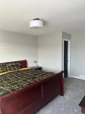 a bedroom with a large bed in a room at 3 Bedroom House in NW Calgary in Calgary