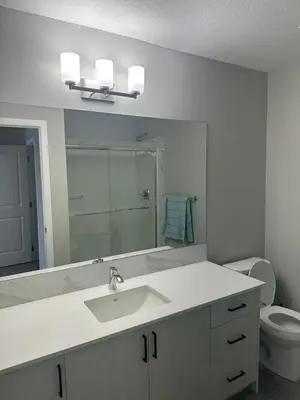 a bathroom with a sink and a toilet and a mirror at 3 Bedroom House in NW Calgary in Calgary