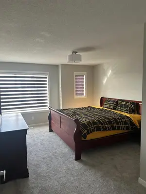 a bedroom with a bed and a window at 3 Bedroom House in NW Calgary in Calgary