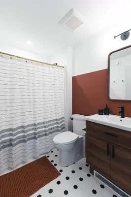 a bathroom with a toilet and a sink and a mirror at Lokis Loft and Cellar at the 1896 Building in Kaslo