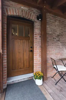a wooden door with a chair and a potted plant at The Crow's Nest at the 1896 Building in Kaslo