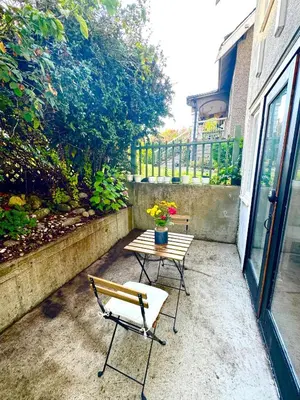 a patio with a table and two chairs and a bench at Bright Garden Suite Across From Park in Kitsilano in Vancouver