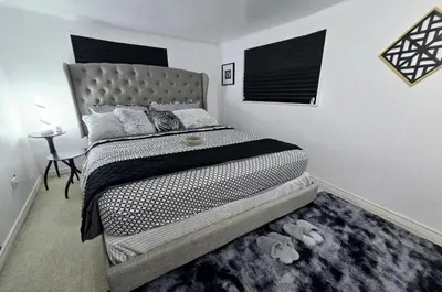 a bedroom with a large bed with a gray headboard at Private Cozy 1Br Basement Suite Perfect for Couple! With Date Bar for 2! Self Check-in, Private Parking in Burnaby