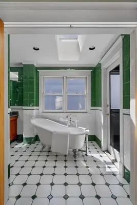 a bath tub in a bathroom with green tiles at The Vancouver Heritage Home - Mount Pleasant in Vancouver