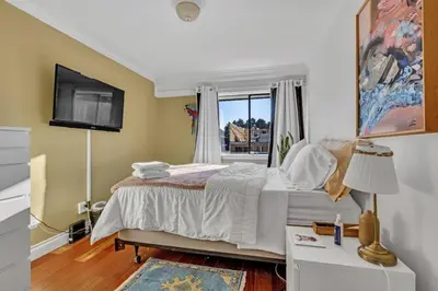 a bedroom with a large bed and a window at Adorable 1-Bedroom Apartment on Kitsilano Beach in Vancouver