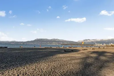 a beach with people and the ocean in the background at Adorable 1-Bedroom Apartment on Kitsilano Beach in Vancouver