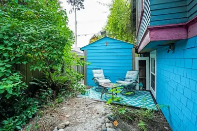 two chairs sitting outside of a blue house at Artsy Private Guest Suite with Outdoor Saloon in Vancouver