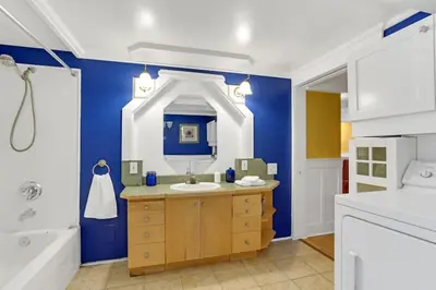 a bathroom with a sink and a blue wall at Artsy Private Guest Suite with Outdoor Saloon in Vancouver