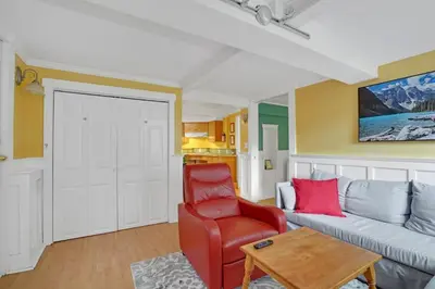 a living room with a couch and a red chair at Artsy Private Guest Suite with Outdoor Saloon in Vancouver