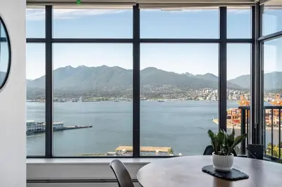 a room with a table and a view of the water at The W, Modernized 2 bedroom Downtown Highrise in Vancouver