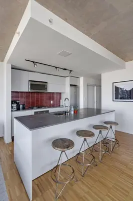a kitchen with a white counter and stools at The W, Modernized 2 bedroom Downtown Highrise in Vancouver