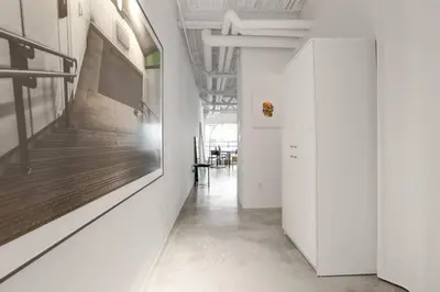 a hallway with white walls and a television on a wall at Modern and Specious Condo right off Main St in Vancouver
