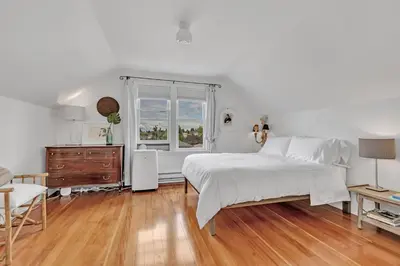 a white bedroom with a bed and a window at The Queen Elizabeth Park Home in Vancouver