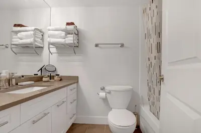 a white bathroom with a toilet and a sink at Modern Kitsilano 1 bedroom steps from the Beach in Vancouver