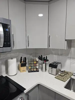 a kitchen with white cabinets and a counter top at Contemporary Two Bedroom Basement Suite in Edmonton