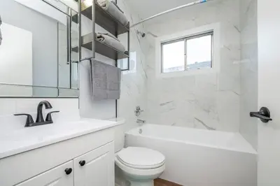a white bathroom with a toilet and a sink at Highland Park Upper Suite in Calgary