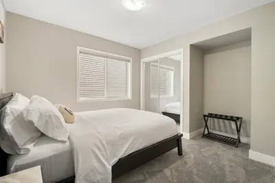 a bedroom with a white bed and a window at A beautiful home in Airdrie in Airdrie