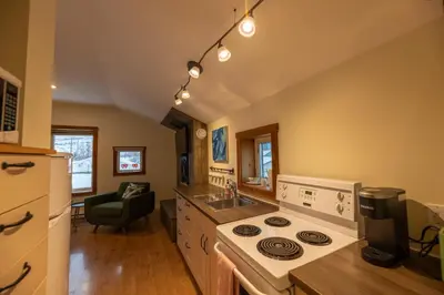 a kitchen with a stove and a sink at Located in Downtown Whitehorse - Treehouse in Whitehorse