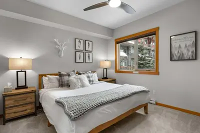 a bedroom with a large bed and a window at Modern Cabin Vibes with pool at The Lodges in Canmore