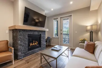 a living room with a fireplace with a tv at New 1Bd Luxe King Suite with Superb Mtn View in Canmore