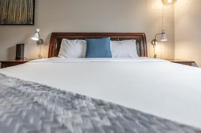 a bedroom with a large white bed with two blue pillows at Stunning Silver Creek 1Br Mtn view penthouse in Canmore
