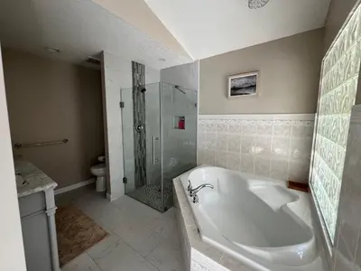 a bathroom with a tub and a shower and a sink at Five Gables B&B in Qualicum Beach