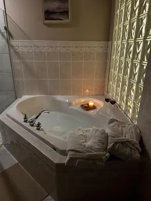 a bathroom with a bath tub with a candle and a candle at Five Gables B&B in Qualicum Beach
