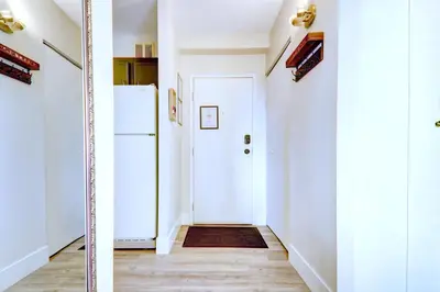 a hallway with a white door and a refrigerator at Spacious Top Floor at Stampede w Free Parking and AC in Calgary